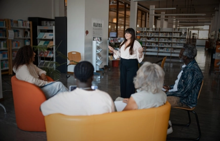 Expositora dirigiendo una charla en una biblioteca, rubro de salud y educación que gestiona RAPIFAC ERP